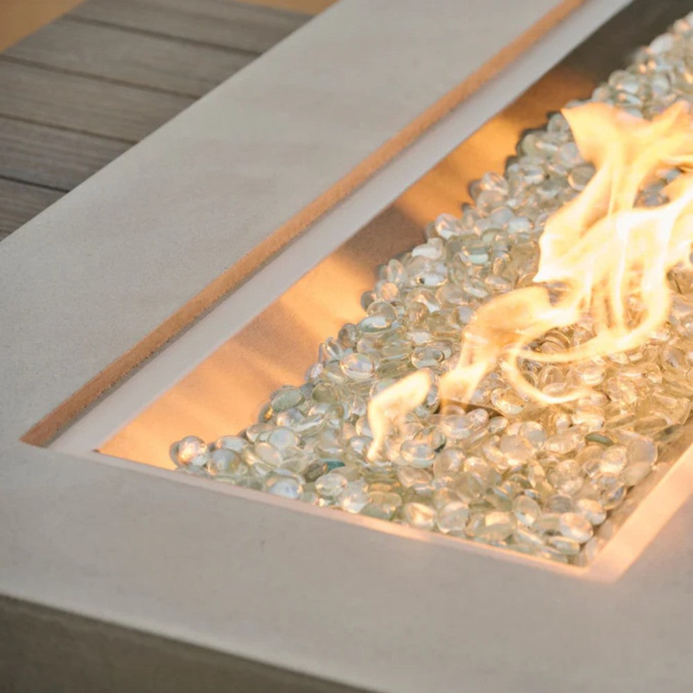 Linear gas fire pit burner tray with glowing flames and clear fire media