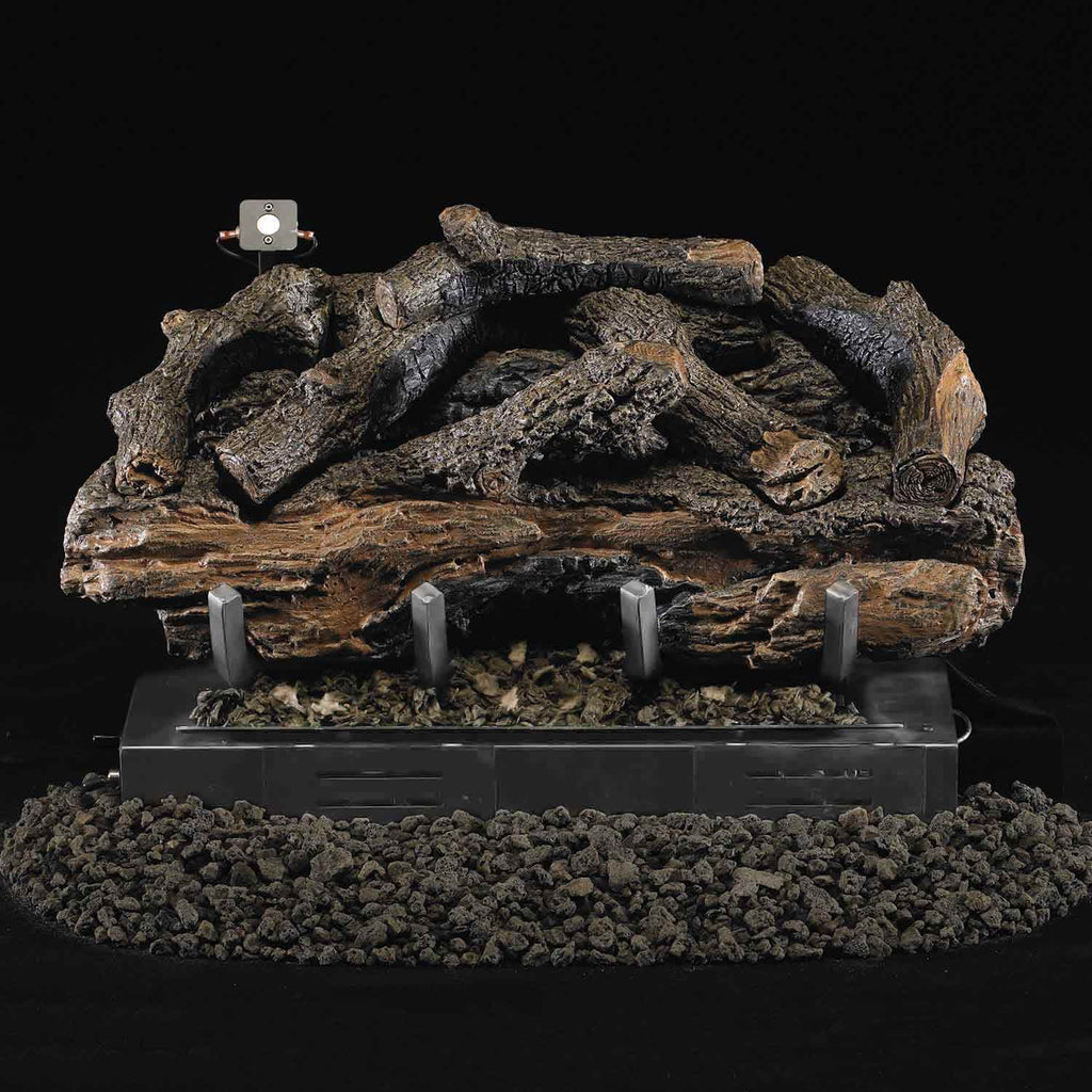 Charred aged gas log set resting on a metal burner base with ember bed and mounting brackets