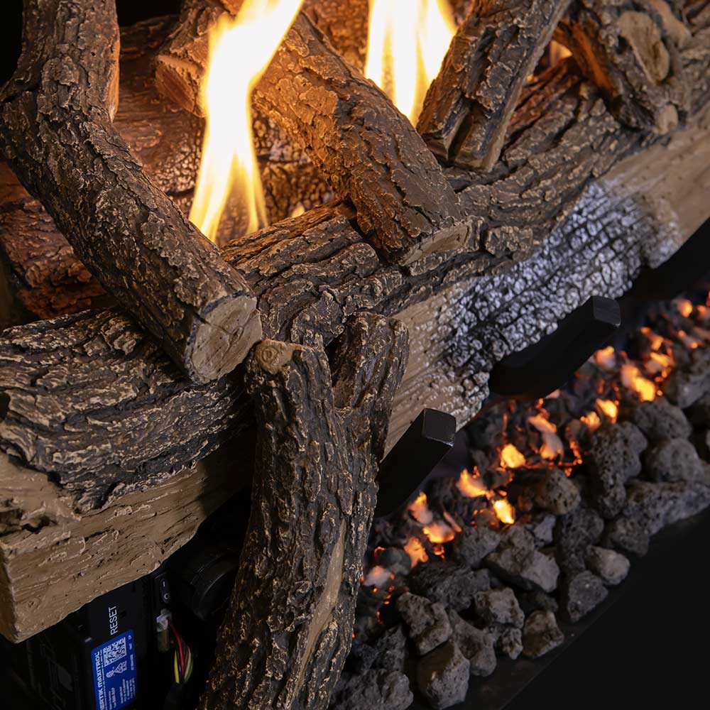 Split oak gas logs with bright flames and charcoal embers in front