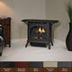 Matte black cast iron ventless gas stove with glass door and burning flame