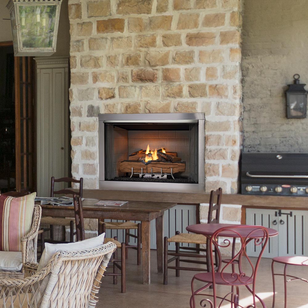 Outdoor gas fireplace set in stone surround with burning log display inside