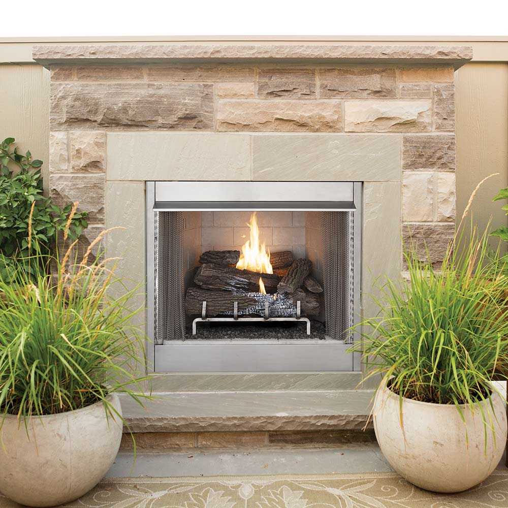 Outdoor vent-free fireplace insert in stone wall surround, front view with burning logs