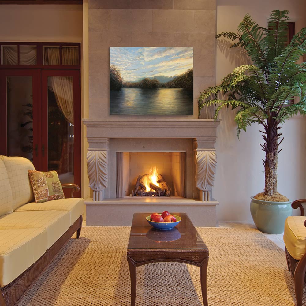 Vent-free outdoor gas fireplace in white stone surround with burning logs