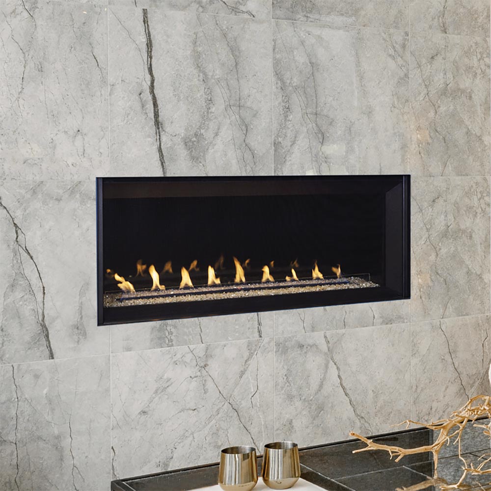 Linear vent-free gas fireplace on stone wall with glowing fire bed and black frame