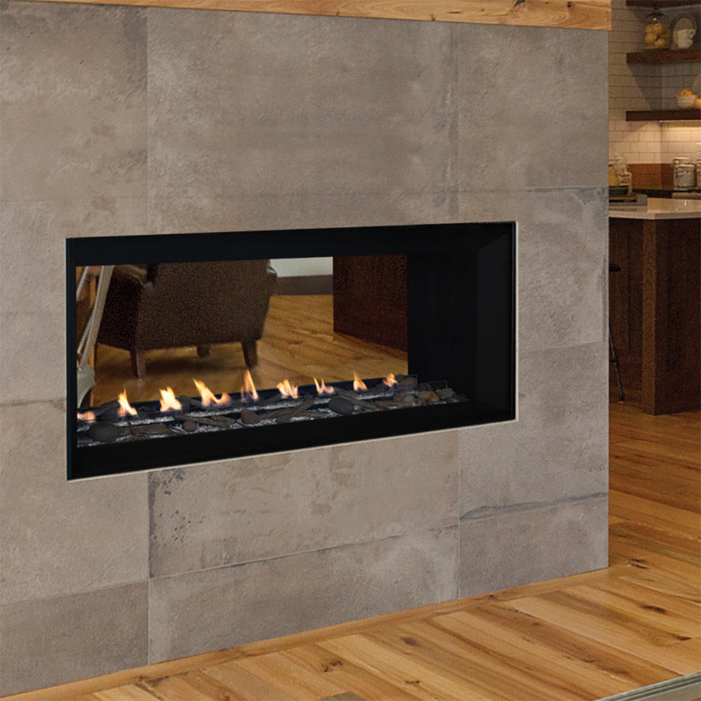 Linear see-through gas fireplace built into a light stone wall with black front