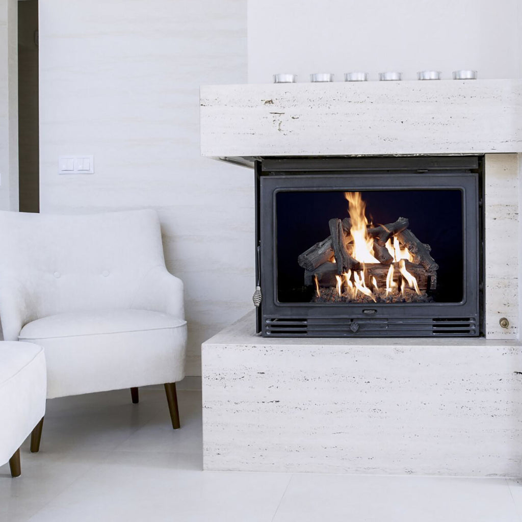 Vented gas log burner inside a black firebox opening with driftwood-style logs and flames