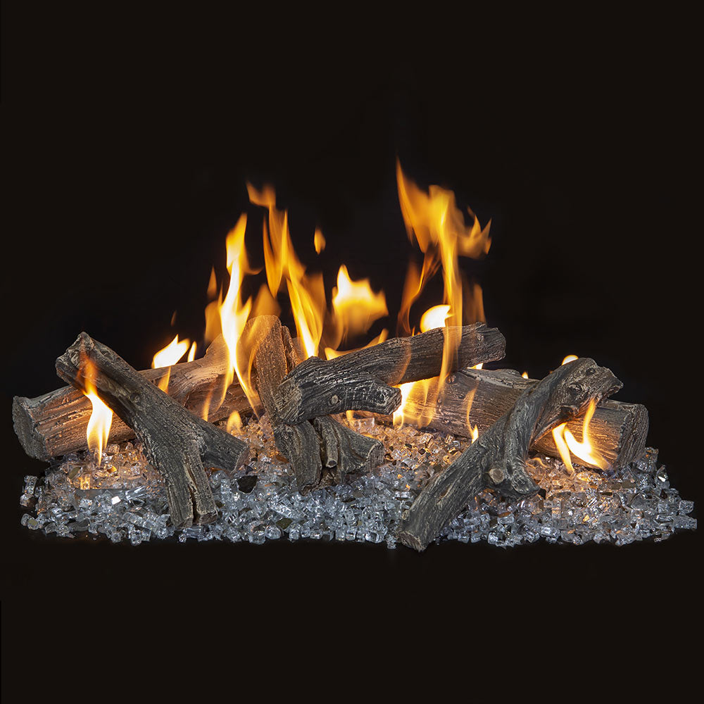Vented gas log set with dark driftwood logs and glowing flames over glass media