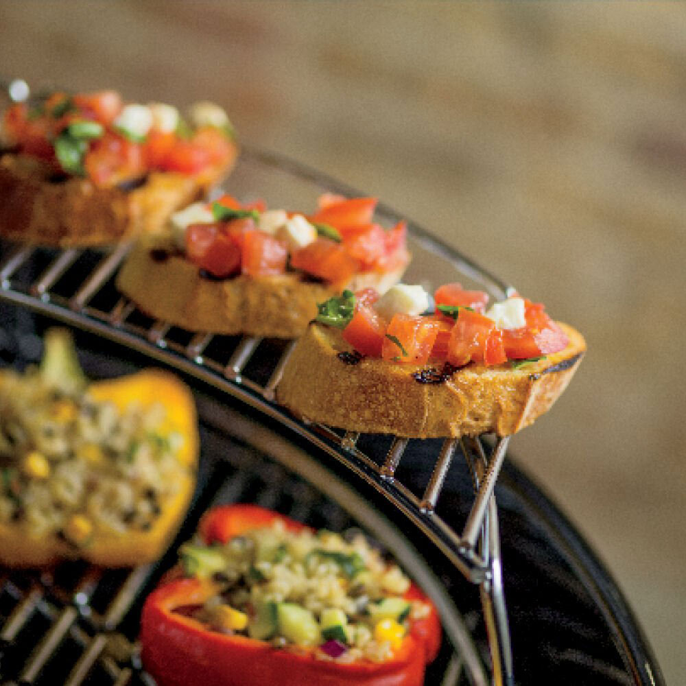 Charcoal grill grates with open-faced garlic bread and toppings