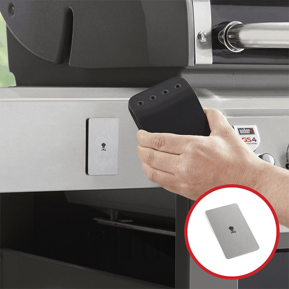 Grill mounting bracket with dark plate and gray control unit shown in hand