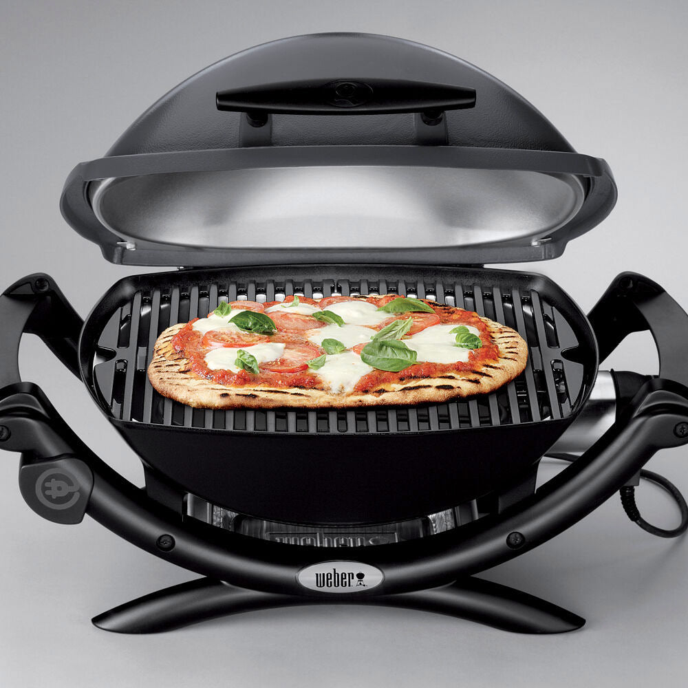 Electric grill with open lid, cooking grate holding a topped pizza