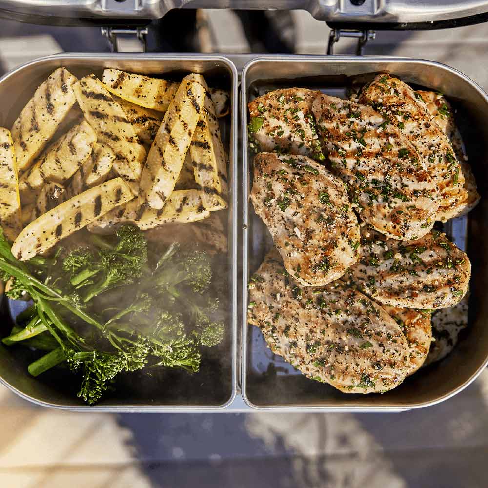 Stainless grill insert trays used for cooking vegetables and chicken