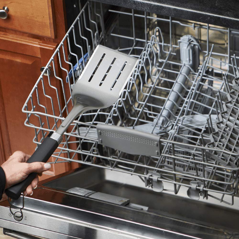 Stainless steel grill spatula placed in dishwasher rack
