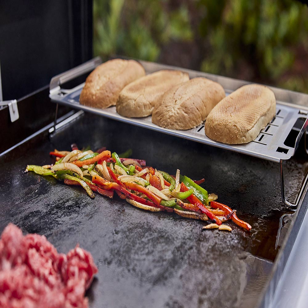 Weber griddle keep warm rack holding buns on top, with angled side handles
