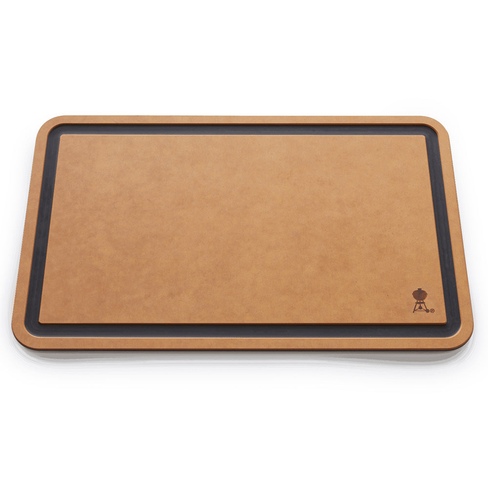 Weber cutting board with tan surface and dark charcoal border, rounded wood-look frame.