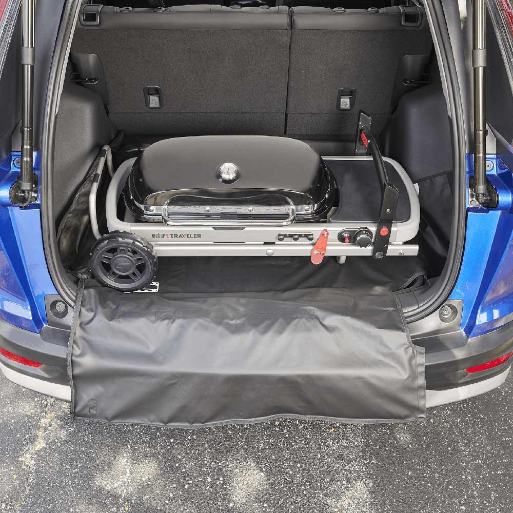 Cargo protector with dark gray cover panel inside vehicle trunk, secured openings and buckles