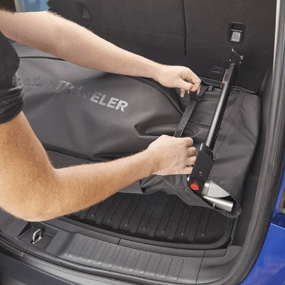 Cargo protector being installed in trunk area, dark gray fabric with straps and handle loops