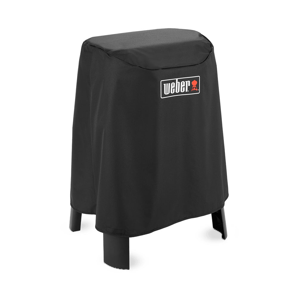 Black grill cover with Weber logo badge, draped fit over grill on stand