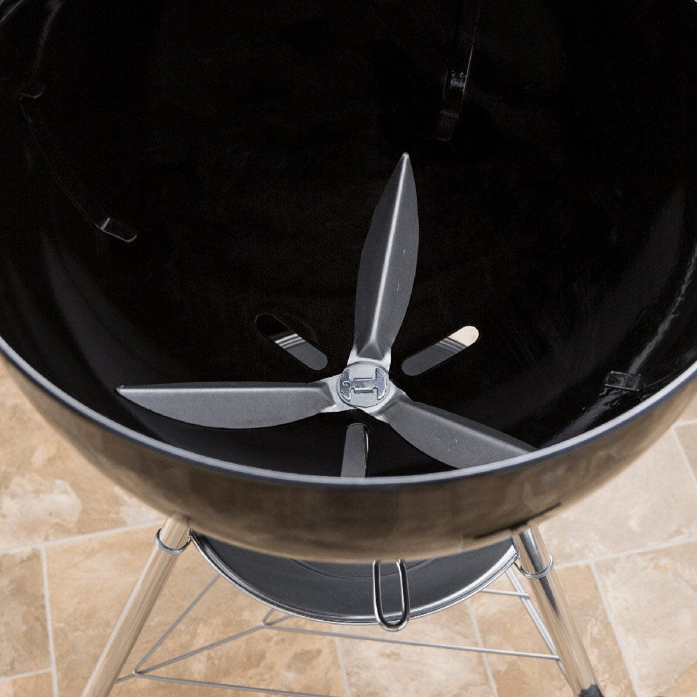Metal cleaning scraper assembly with four blades inside a charcoal grill