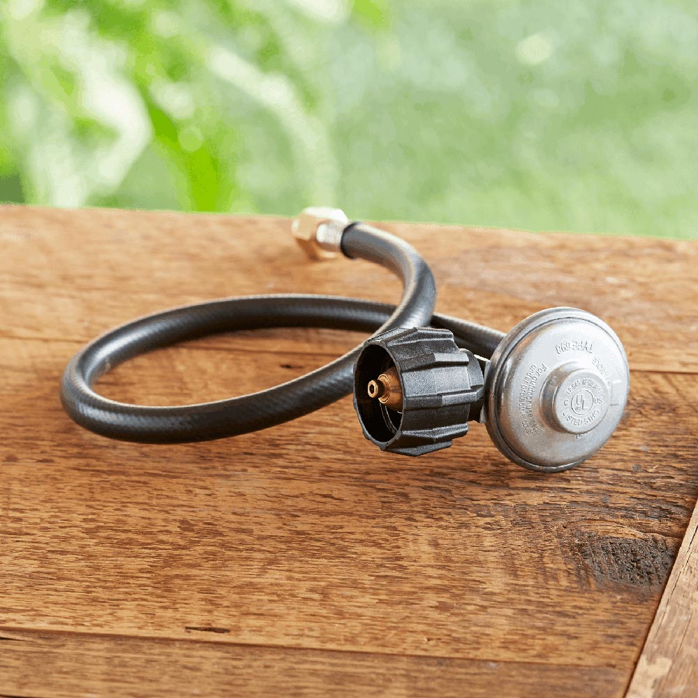 Propane regulator with metal top and black hose, visible connection on end fitting