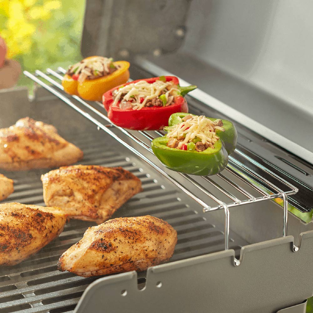 Warming rack wire bars on grill grate with peppers and meat pieces visible