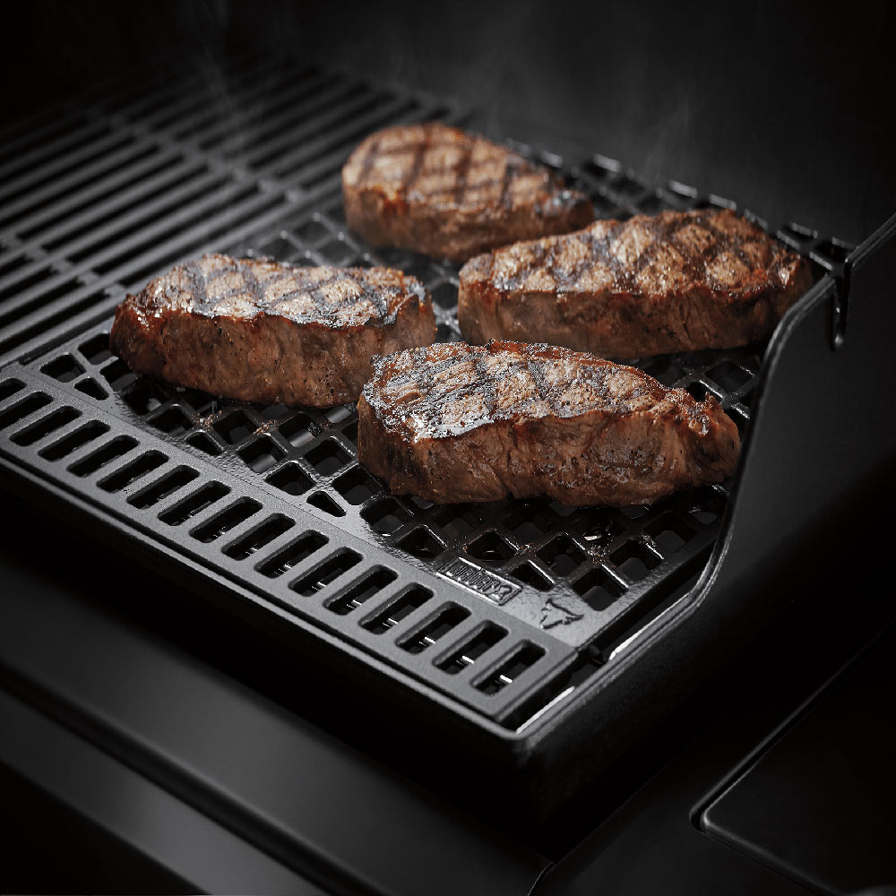 Sear grate with grilled meat patties on a black metal grid