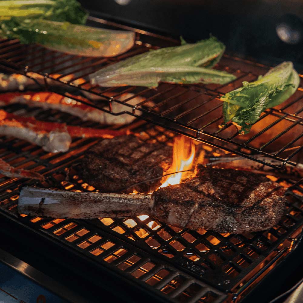 Sear grate with grilled meat, green vegetables, and visible flames