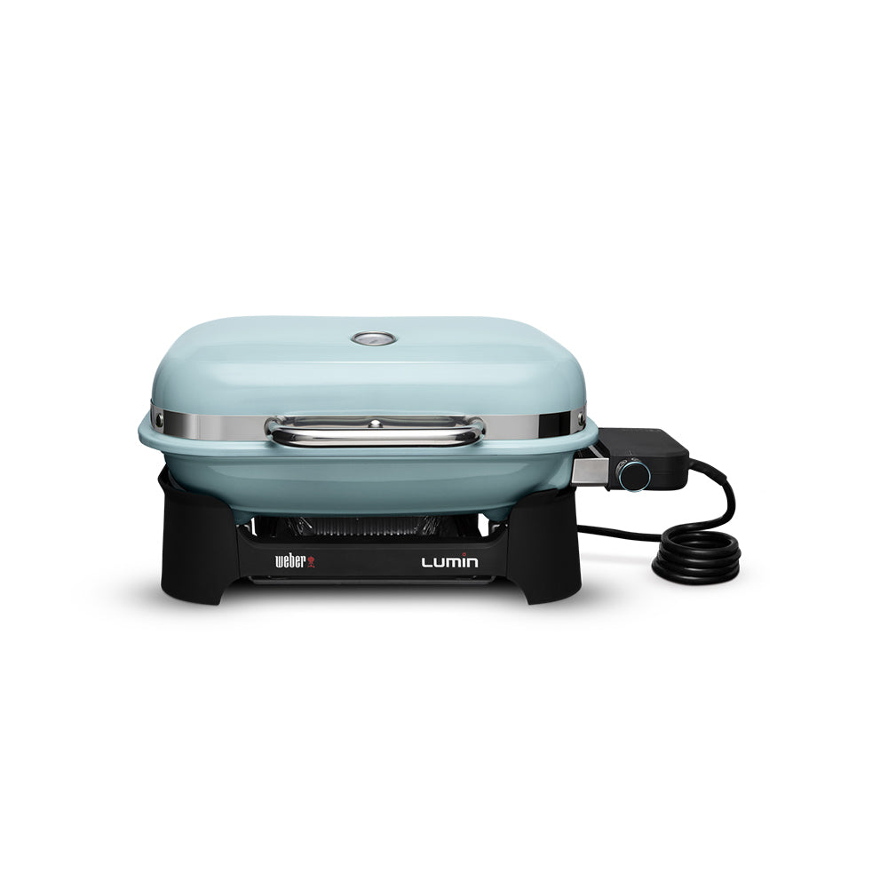 Portable electric grill with light blue lid, control knob, and power cord
