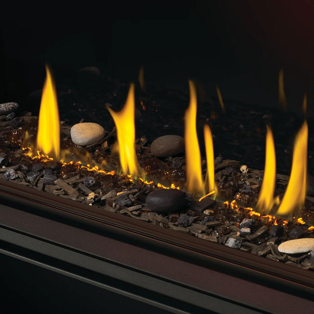 Fireplace burner media with stacked stones, pebbles, and tall flames along the tray