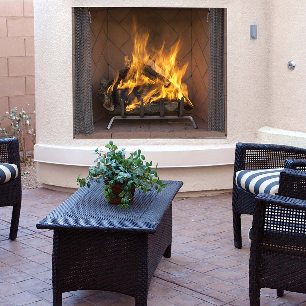 Outdoor wood-burning fireplace with burning logs and dark mesh screen opening