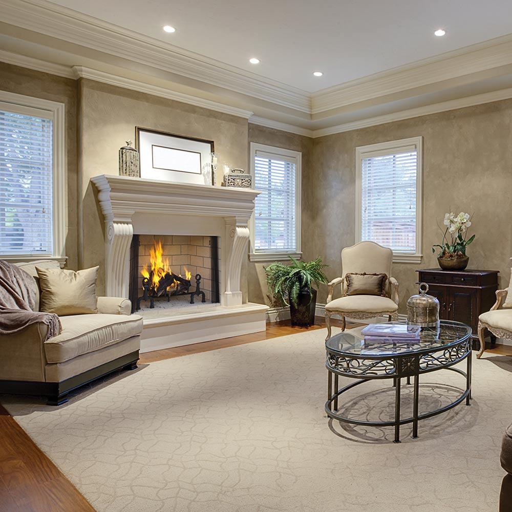 White fireplace mantel with wood-burning fire and black andirons inside