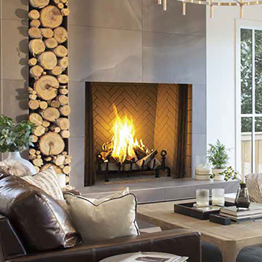 Masonry wood-burning fireplace with split herringbone tile firebox wall and burning logs