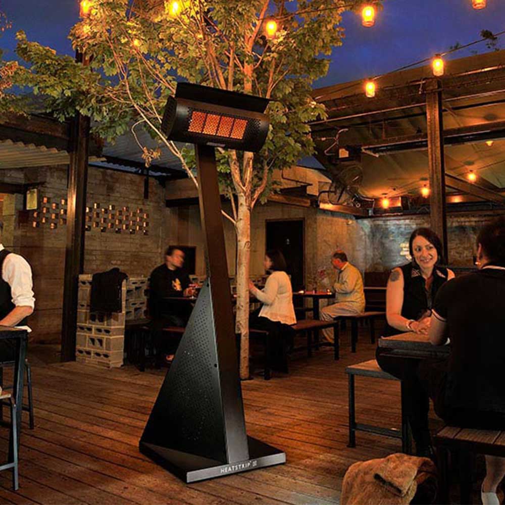 Patio LPG gas heater with glowing orange heat grid and black protective hood