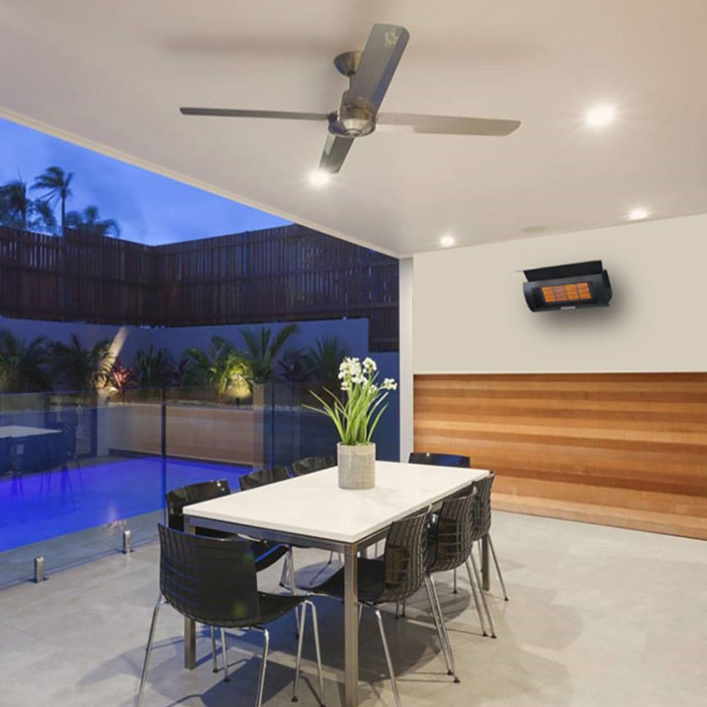 Outdoor wall mounted heater with glowing orange heating element and black housing