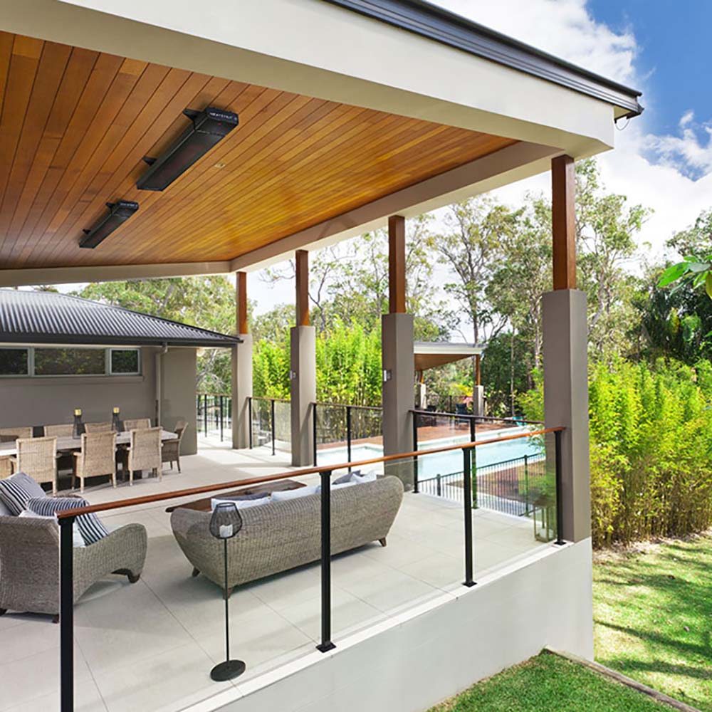 Wall-mounted outdoor electric patio heater unit on a covered patio ceiling