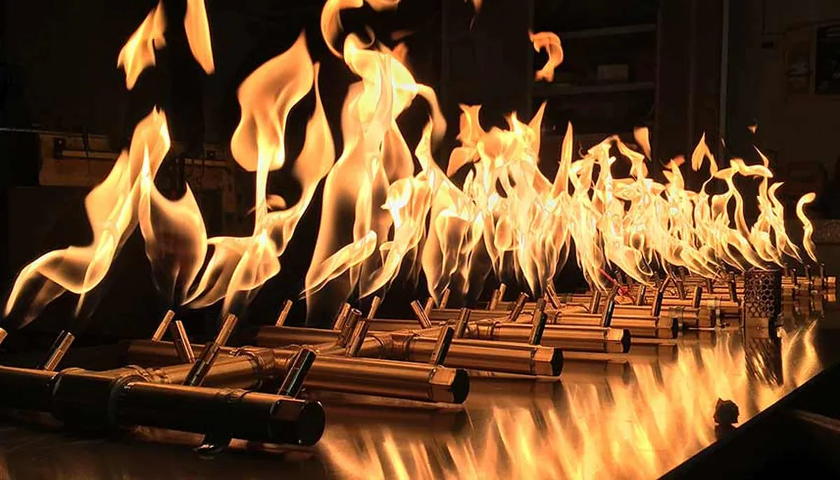 Warming Trends Crossfire brass burner system with multiple tall flames burning in a factory test — fire pit ignition system options