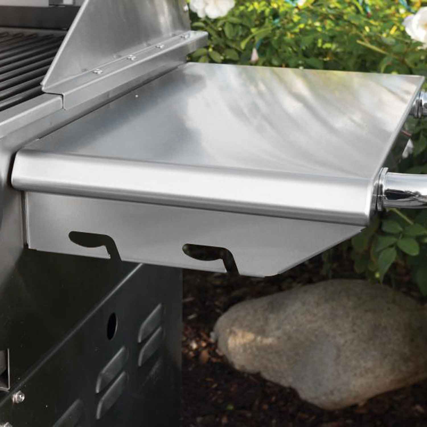 Stainless steel grill hood and open cooking surface, with side shelf below