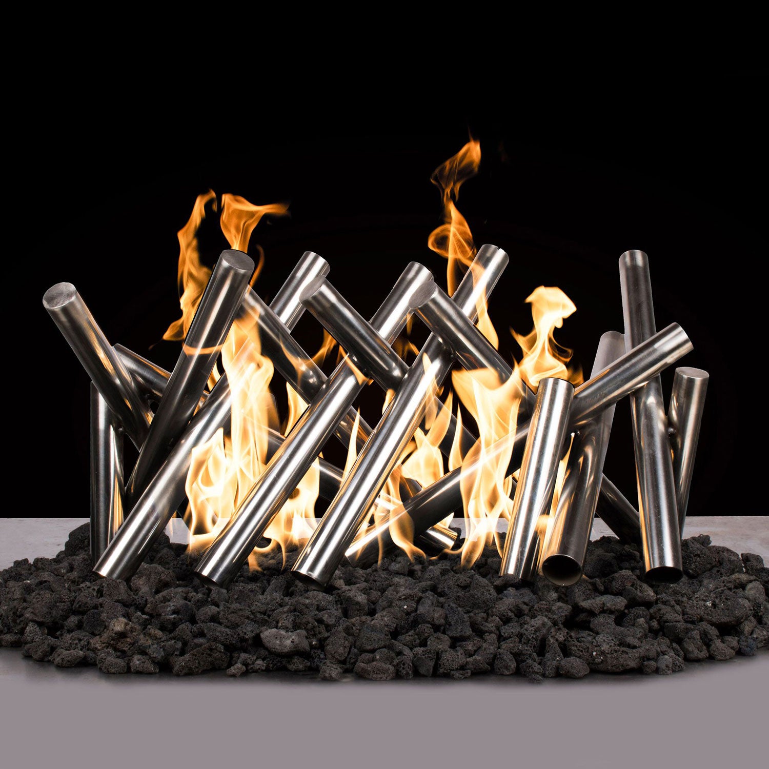 Polished stainless steel fire log set with flames rising from the cylinders