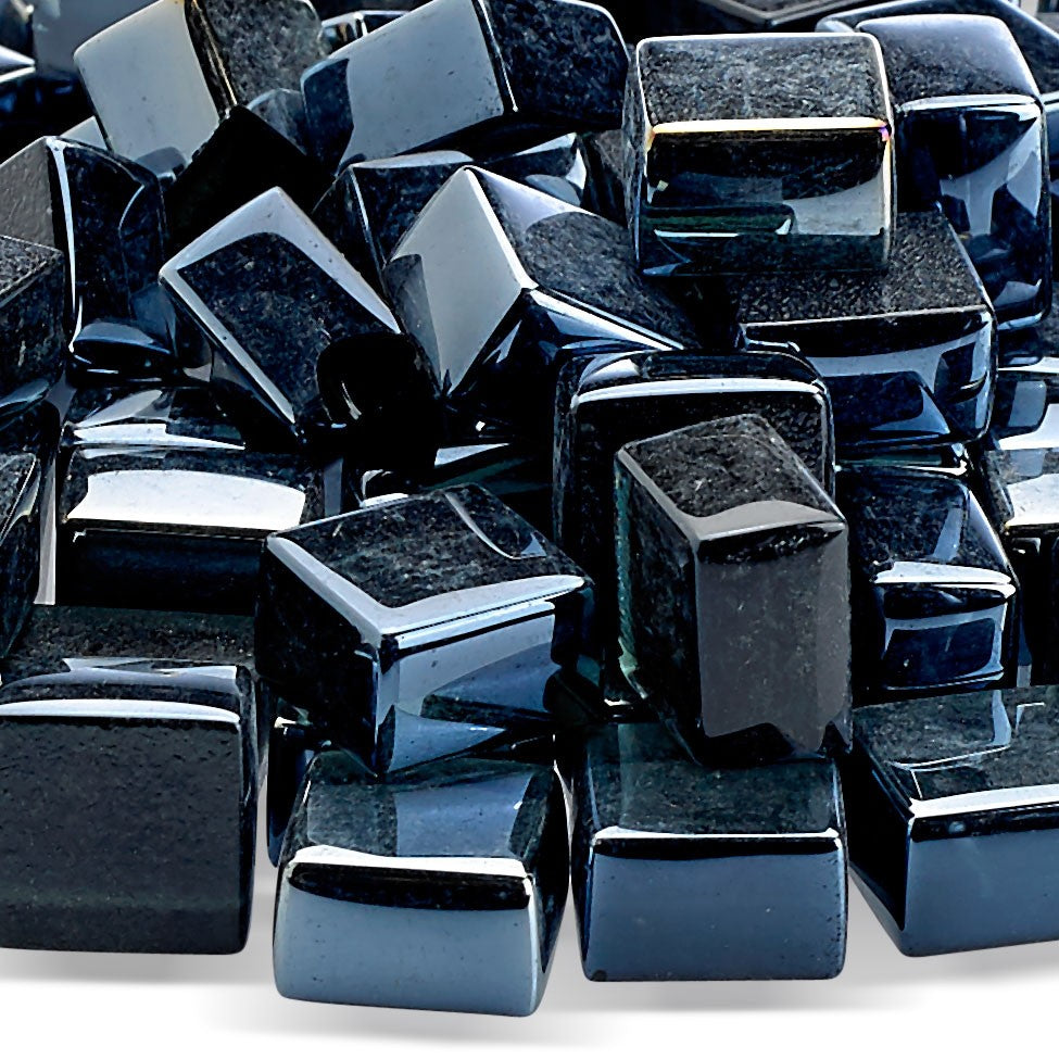 Close-up of black glossy fire glass cubes with reflective highlights
