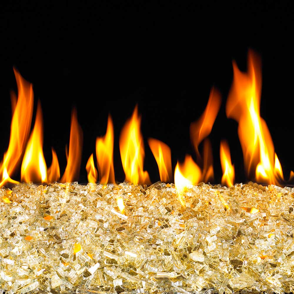 Gold reflective fire glass covering a fire pit with orange flames