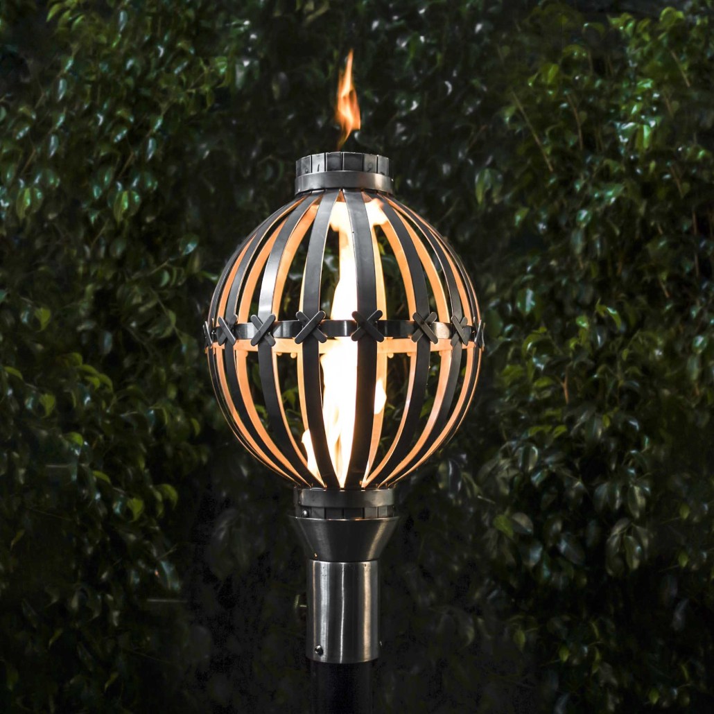 Globe outdoor torch with black metal cage and visible flame