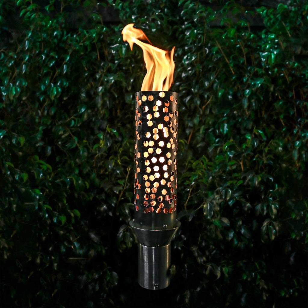 Outdoor torch with honeycomb metal body and burning flame, on dark stand base