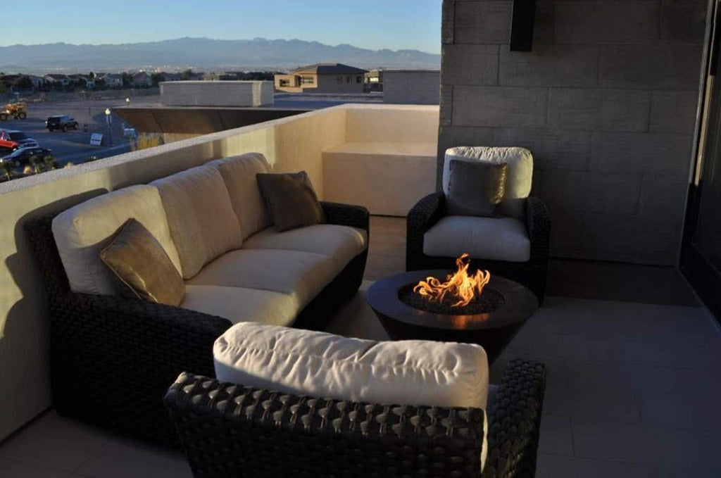 Hammered copper fire bowl with flame display on patio surface