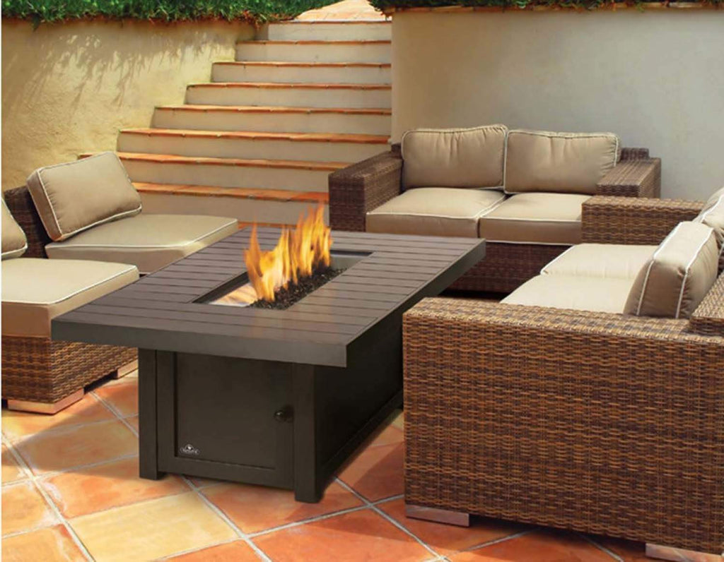 Outdoor fire table with dark tabletop and flames, set within a patio seating area