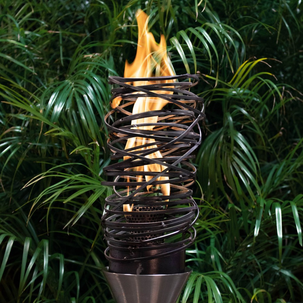 Outdoor gas torch with metal stand, burning flame in black spiral burner cage