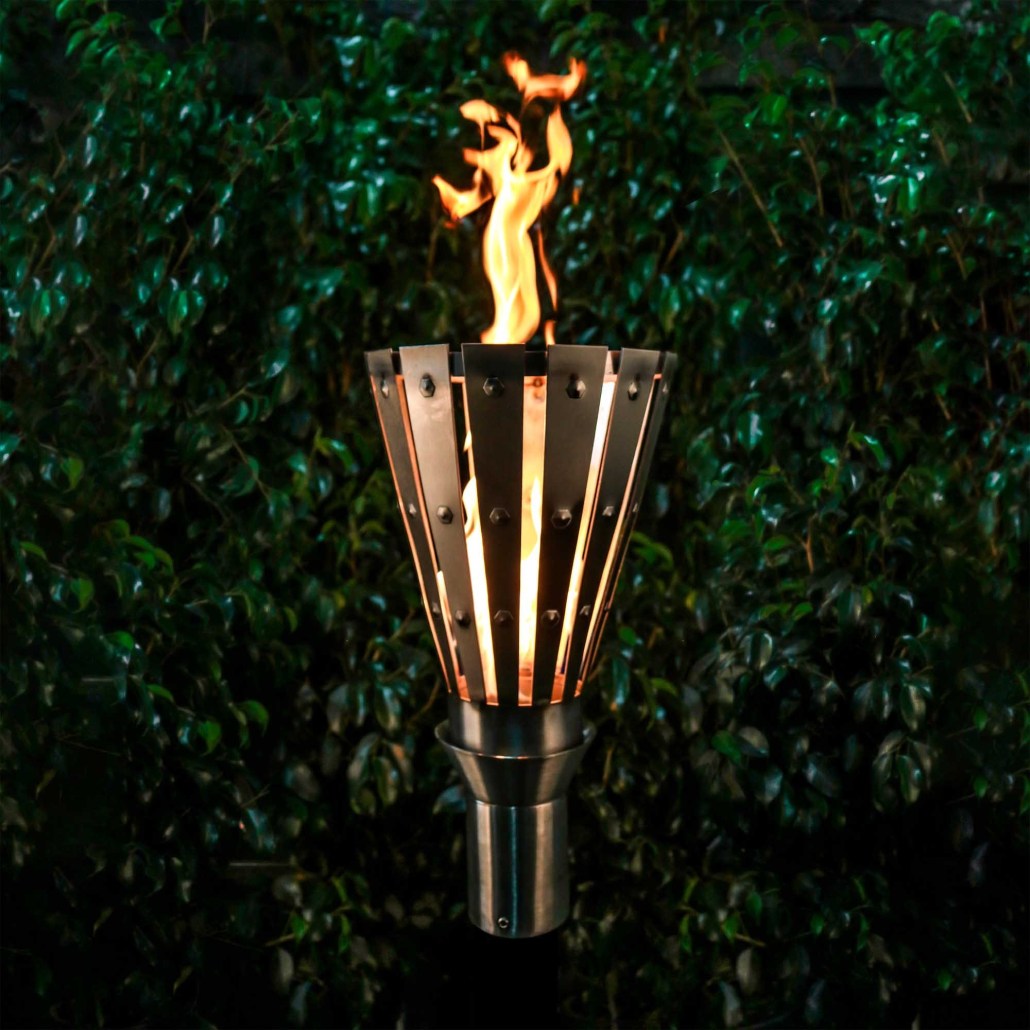 Outdoor flame torch with metal fan-style surround and vertical stand, lit with orange fire