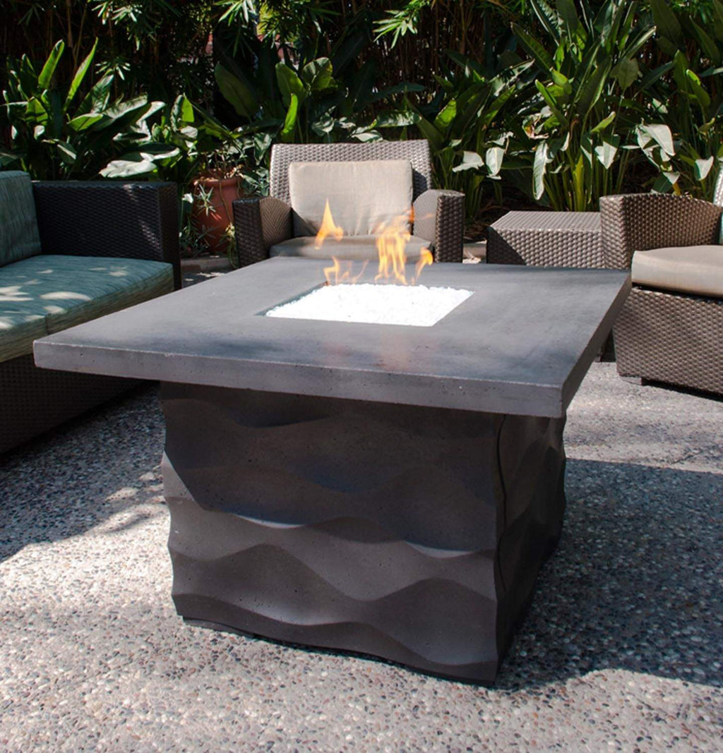 Square fire table with dark base and burning flame, outdoor side view